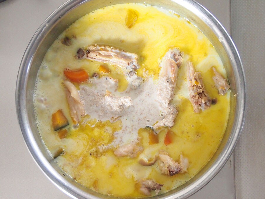 (5) 鶏肉が骨からするっと外れるくらい柔らかくなったら、豆乳、白すり胡麻を入れます。
