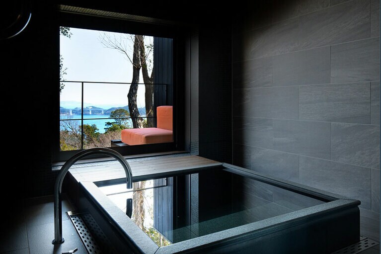 ゆったり浸かれる和奏スタイルの浴槽。スライド式の窓を開けると、海原から流れてくる微かな風が心地よい。湯上りにデッキで火照った身体を休ませると至福の気分に。