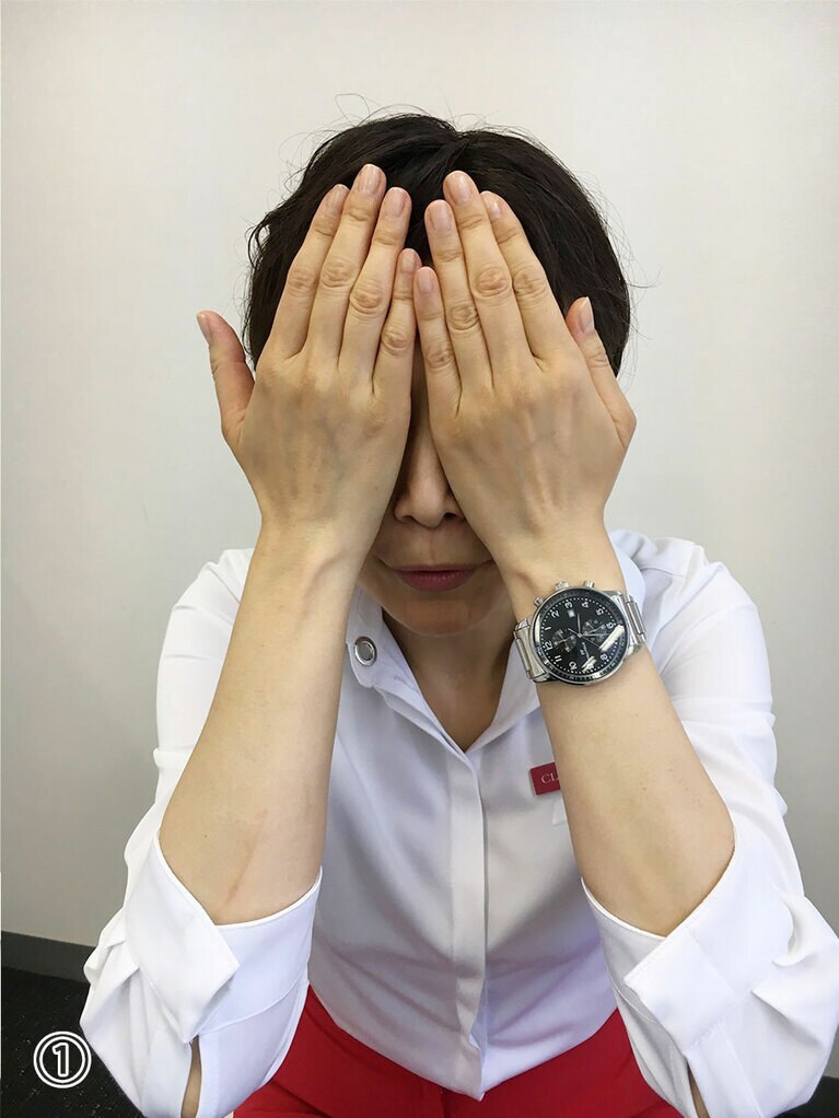①顔を正面に向け、両手のひらの「下のハラの部分」でしっかり目と「目の周り」を覆い、指でおでこを包み込むようにして覆います。