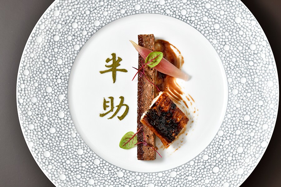 大阪料理の世界で “半助” と呼ばれて親しまれている鰻の頭を、フランス料理のスタイルにアレンジ。半助の文字は山椒の粉で描かれています。