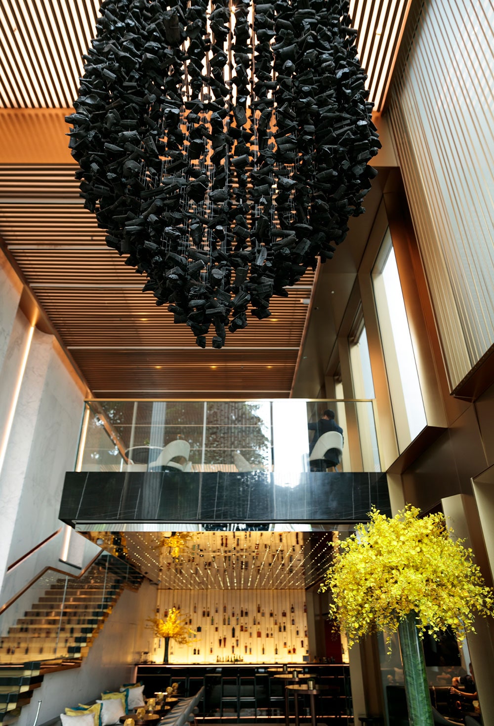 ロビーラウンジを見下ろす壮大な炭のアートワークはホテルの象徴。