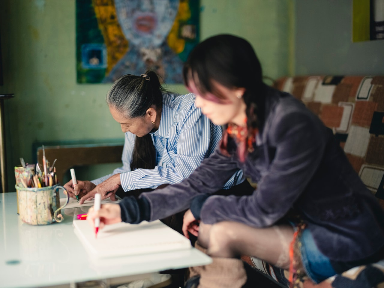 撮影中、スケッチブックに絵を描く二人。