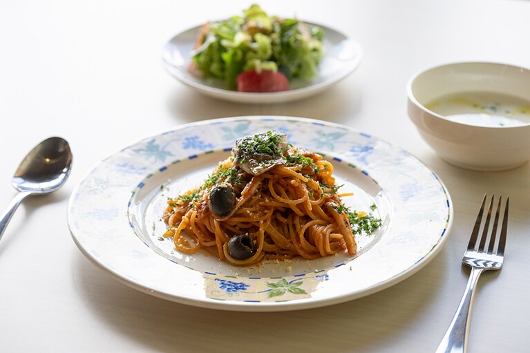 サラダとスープが付いた「佐渡産魚介とオリーブのトマトソースパスタ」1,300円。