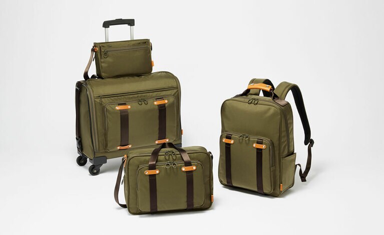 左上より時計回り：A4二つ折りサイズが入るショルダー小 (24×16×6→10㎝※) 8,000円。リュック小(29×38×13→18cm※) 17,000円。A4サイズが入るショルダー大 (32×23×8→13㎝※) 12,000円。トローリー (45×40×23㎝) 33,000円。全てブラック、ネイビー、カーキの3色展開。ナイロン製。5月発売予定。※矢印はマチ幅を拡げた時のサイズ