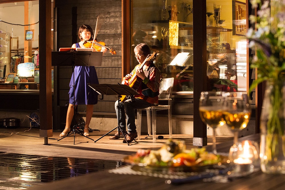 「丸山珈琲」前のテラスでチケット(1,000円／税込)を購入して会場内へ。バイオリンやチェロなどの生演奏が心地よく自然の中に響き、優雅なくつろぎの時間を演出する。