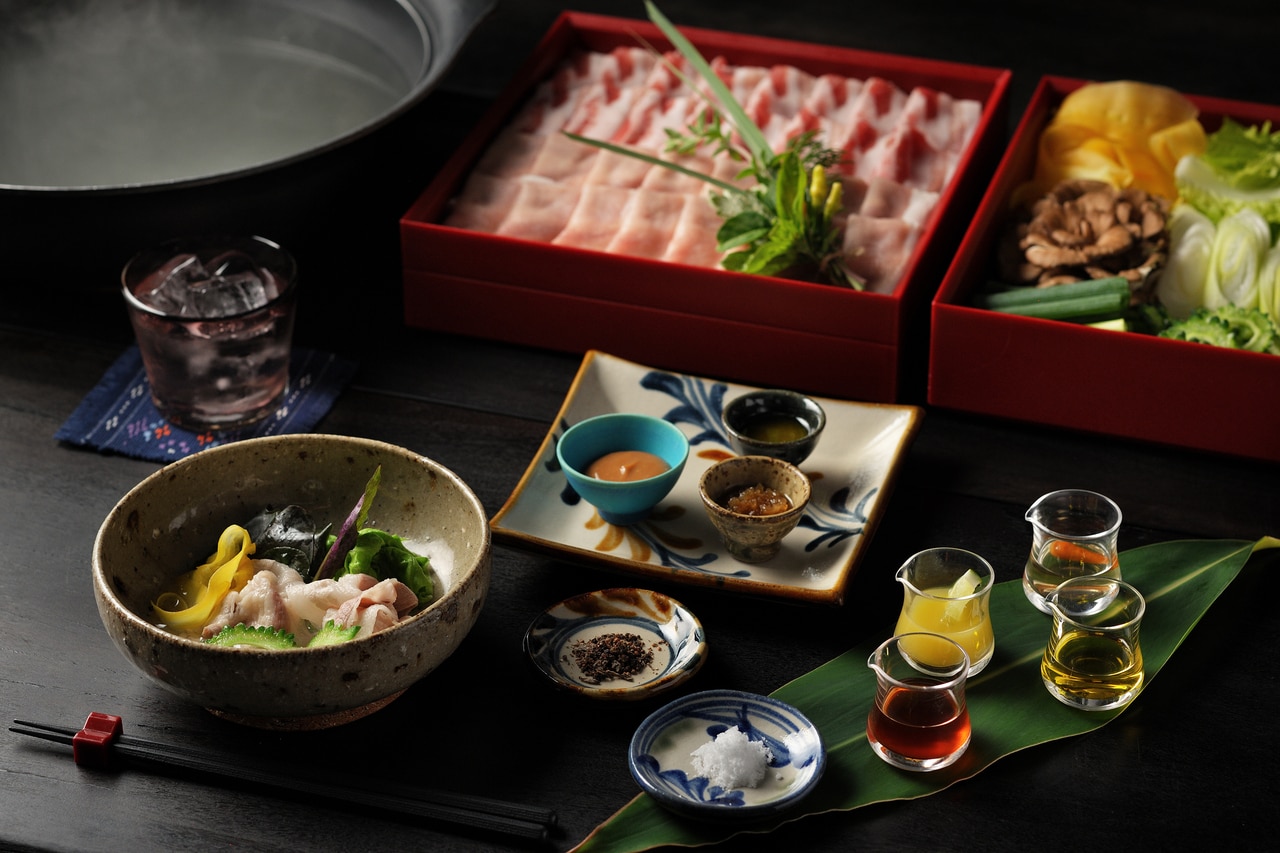 黒瓷の器に盛られた伝統的な会席料理。