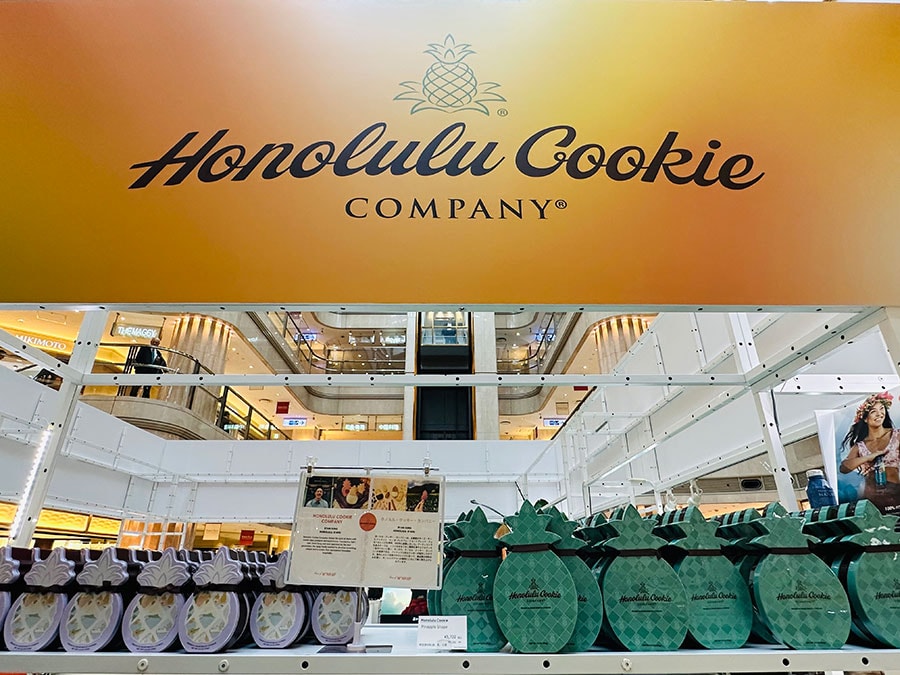 ハワイといえば、定番の「ホノルルクッキー」。左が25周年スペシャル 2,592円、右がパイナップルシェイプボックスL 5,702円。