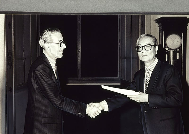 1986年、パリ・ルーブル美術館館長室にて握手するユベール・ランデ氏とルーブル彫刻美術館の初代館長・竹川勇次郎氏。
