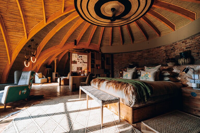 客室内には地元アーティストのイラストやルワンダの女性グループが手がけた刺繡のクッションがあり目を引く。©Wilderness