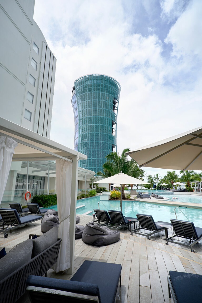 左：タワーのルーフトップバー「Rocco」は16時～22時30分。17時までは“サンセットバブルズ”タイム。スパークリングは8ドル。
右：プール越しに眺めるタワー。