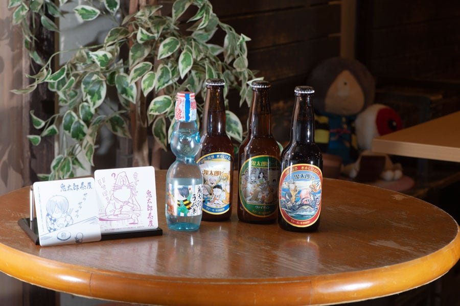 ゲゲゲの鬼太郎ラムネ 200円(税込)と、鳥取県の地ビールである鬼太郎ビール 各660円(税込)。冷たい飲み物を頼むと非売品のコースターがランダムで1つもらえる。©水木プロ
