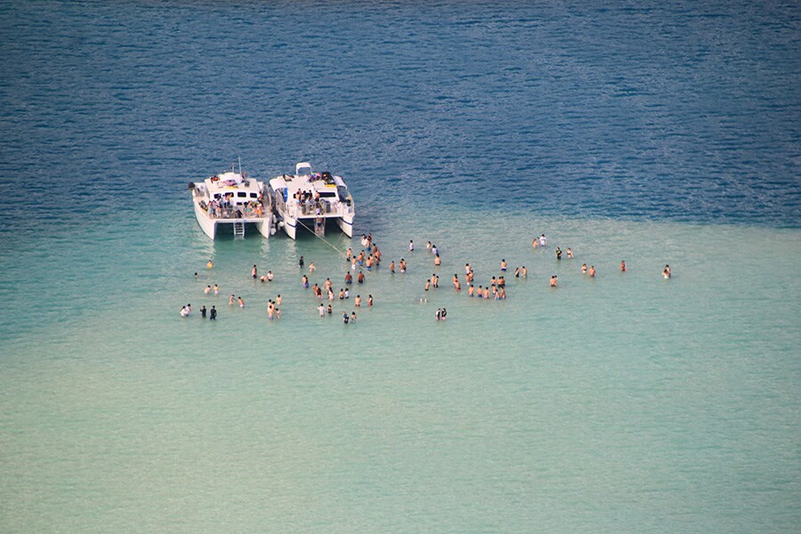 浅瀬で遊んでいるカタマランツアーの観光客は米粒のように小さく見える。