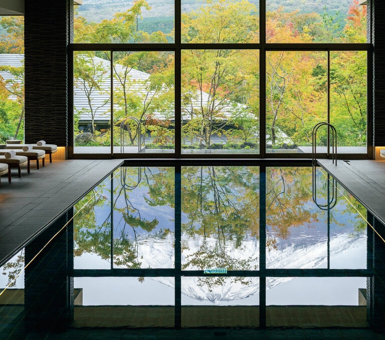 富士山の伏流水を湛えたプールは窓の先の富士山頂まで一直線に伸びる設え。24時間使用できるフィットネスルームを併設。