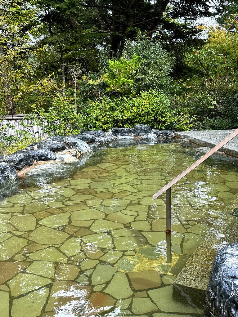 木立に囲まれた露天風呂。渓流の音が心地良い。