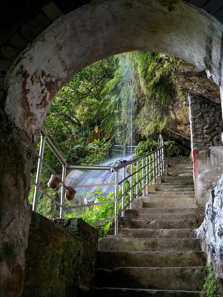 祠の奥にある、滝の裏に続く小道。この日は水量が少なめ。