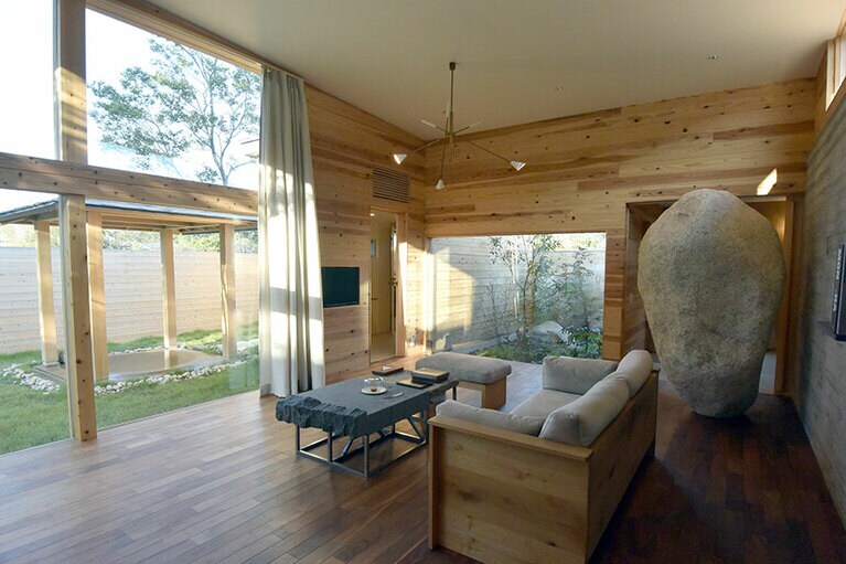 菰野町のヴィラリゾート「湯の山 素粋居」。石をテーマにした棟には巨岩がリビングに。