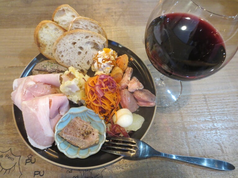 夜のメニューより「本日の前菜盛り合わせ（パン付き）」1,430円。自家製ロースハムや自家製レバーパテ、ポテサラなど、バラエティに富んだ味わい。もちろんパン付き。パンの追加は330円。グラスワイン550円から。