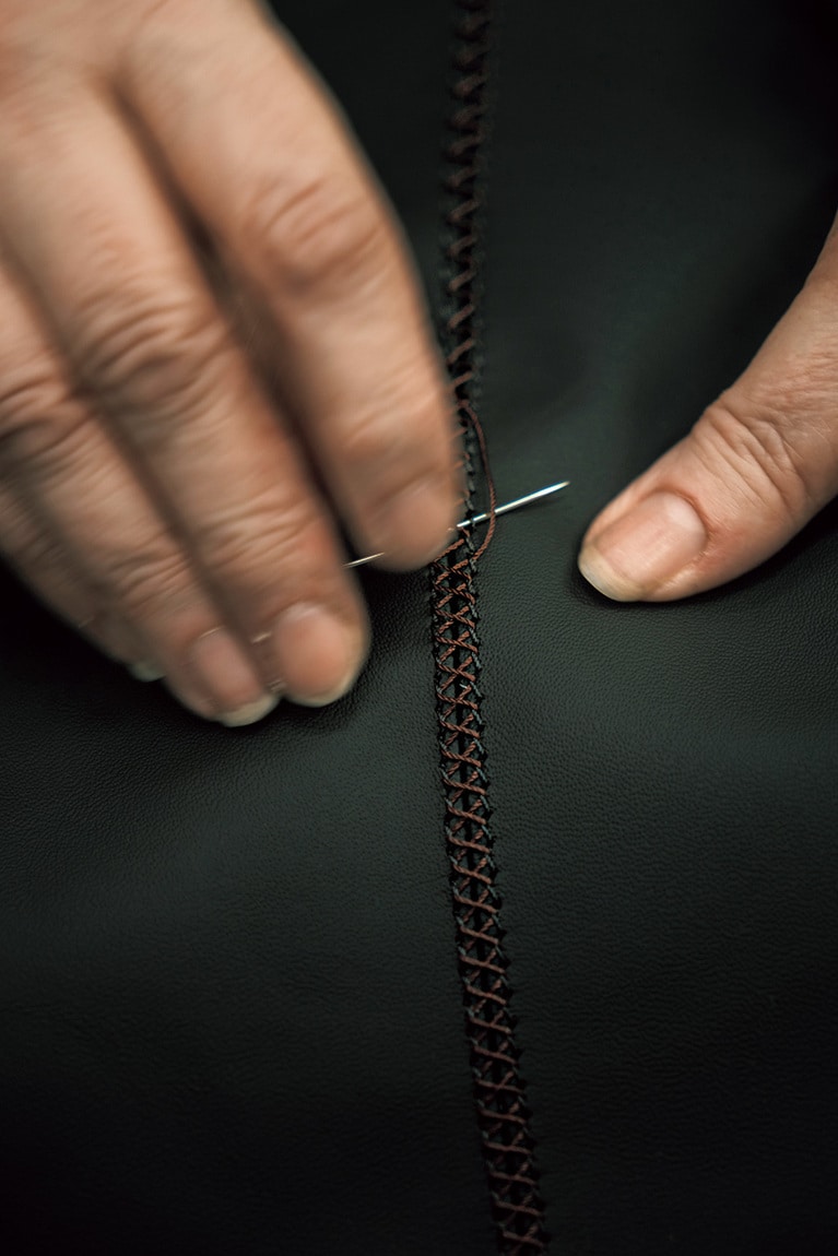 レザーを手縫いしていく作業。あっという間に1枚が完成。