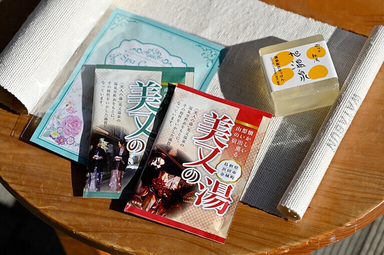 浜田市観光協会特産品販売所には、市内の美肌温泉とコラボした商品なども。手前から、「美又の湯」各183円、「美又温泉水配合スパセラミト フェイスマスク」550円、旭温泉源泉配合せっけん 660円、保湿に優れた成分を含む浴用タオル「キビソ肌友だち」1,650円～。