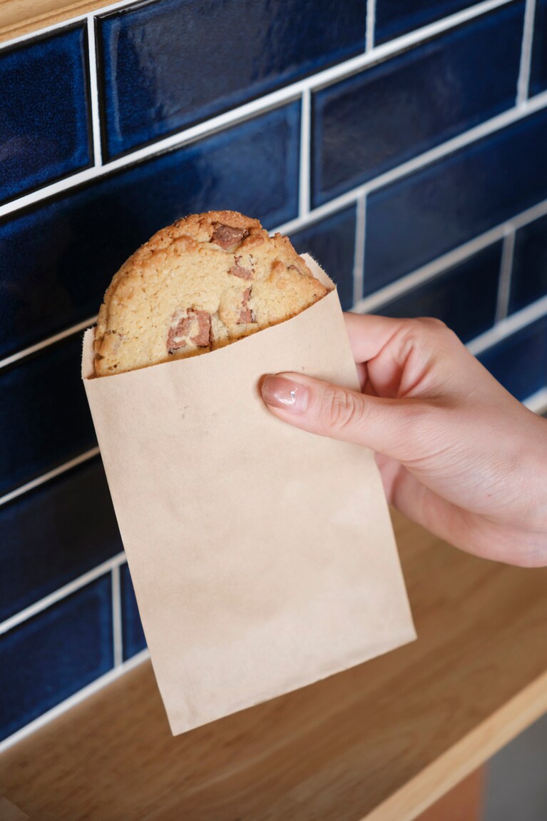 チョコレートがたっぷり入ったチョコレートクッキー300円、ローストコーヒー（100g）1,200円。インテリアのアクセントになっているタイルは、タイル職人の愛子さんのおじ様の開店祝い。