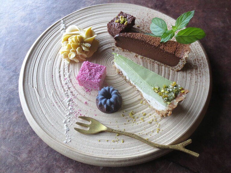 「本日のロースイーツプレート(ドリンク付き)」2,300円。左上から時計回りで「フラワーローケーキ」「ローブラウニー」「アボカドチョコタルト」「ピスタチオとレモンの2層のケーキ」「ローチョコレート」「ローガナッシュ(ピンクドラゴンフルーツ)」。