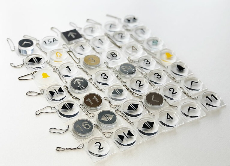 キーホルダーながら、本物のエレベーターボタンと同じ作業工程を踏み、職人の手で一つひとつ丁寧に作られている。