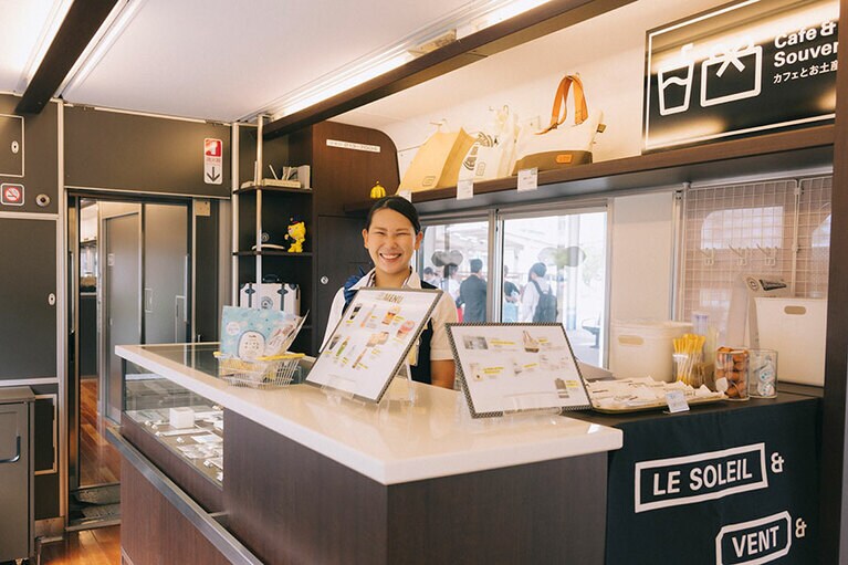 2号車の車内販売カウンターでは、帆布バッグやタオル、文房具など旅の記念になるオリジナルグッズも並ぶ。