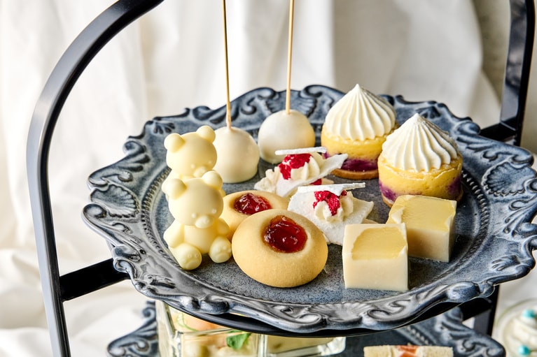 スタンド上段のイメージ。白くまをかたどったホワイトチョコレート、いちごジャムを乗せたルビーのペンダントのような見た目のしっとり食感のホワイトクッキーなどが並ぶ。