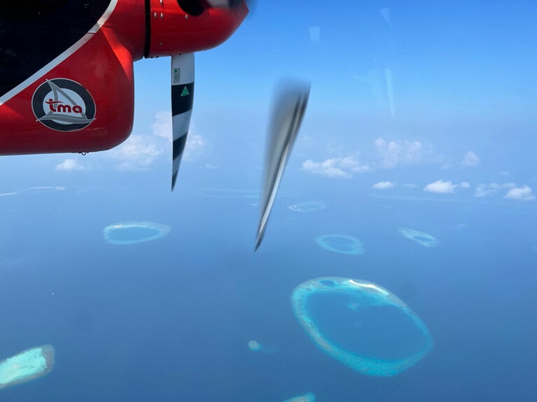 国際空港から離れたリゾートへは水上飛行機で飛ぶ。窓からサンゴ礁の絶景を眺めながらの移動だ。