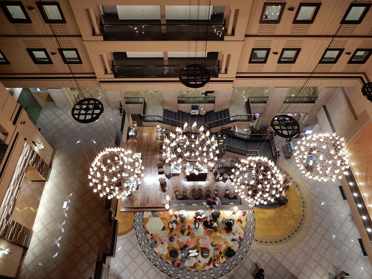 「キロロ トリビュートポートフォリオホテル 北海道」の吹き抜けのロビーでは、ゲストが寛いでいた。冬は暖炉がともる。