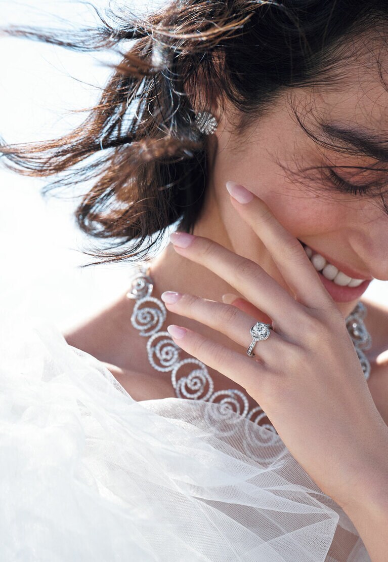 〈左手・薬指〉「ボッチョーロ」エンゲージリング（PT×センターDIA0.3ct～）677,600円～〈左手・人差し指〉「ヴェラモーレ」マリッジリング（YG×DIA）185,900円 〈右手・指先から〉「マルゲリータ」リング（WG×DIA）627,000円 「ペルセンプレ」リング（PG×DIA）413,600円 「ボッチョーロ」ネックレス（WG×DIA）14,014,000円 「マルゲリータ」ピアス（WG×DIA）1,133,000円、バングル（PG×ブラウンDIA）559,900円、（WG×DIA）677,600円／すべてダミアーニ（ダミアーニ 銀座タワー） ミニドレス（参考商品）／ミリア ロンドン（ドレッシーズ スタジオ アオヤマ）