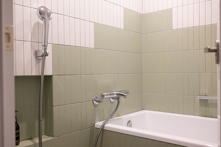 バスルームも部屋の壁紙と同じ配色で統一感あり。ショップで販売している晩白柚の入浴剤で、香りに癒やされるバスタイムを。