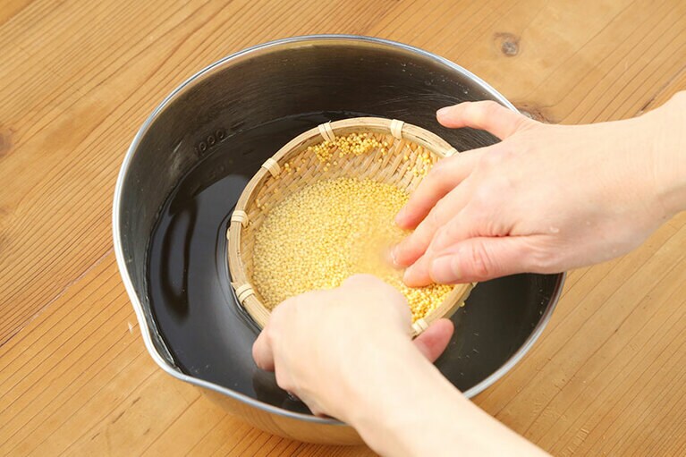 もちきびを洗う。目の細かい竹ザルを利用すると洗いやすい。