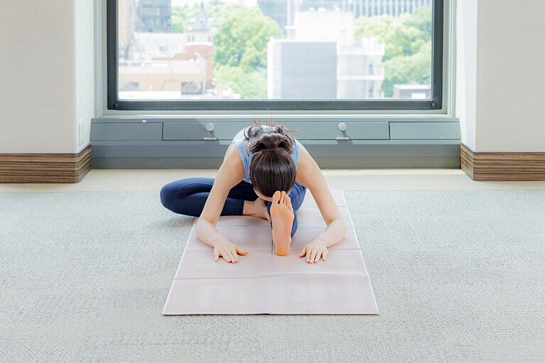 前屈したままゆっくりと5呼吸繰り返して。前屈の際、もも裏が突っ張るときは、伸ばしている方の脚のひざを少しだけ緩めてお腹と前ももを近づけるようにすればOK。終わったら、反対側の脚も同様に行って。