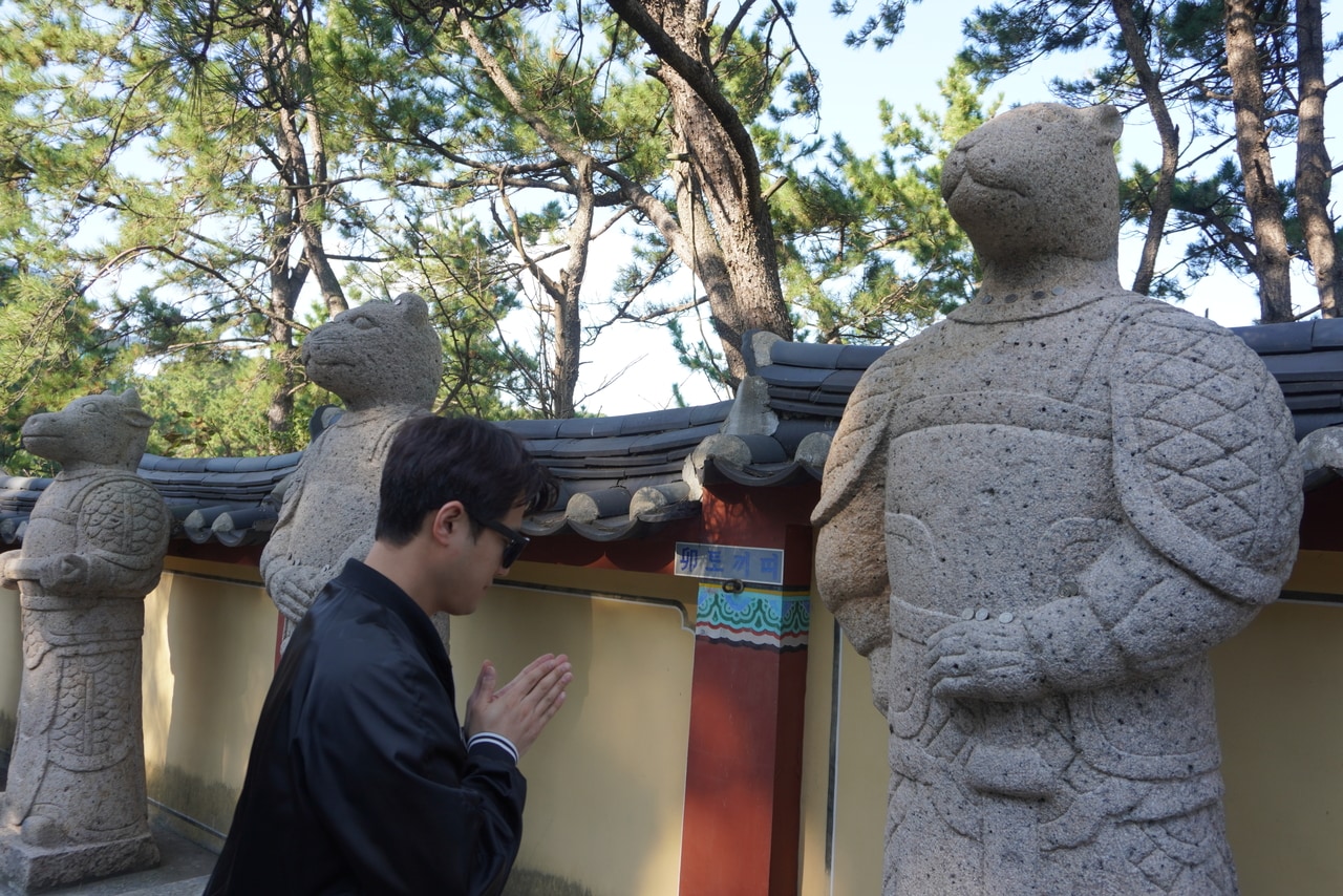 干支の像にお祈りをするジュニョンさん。ネズミのようだけど、これはウサギ！