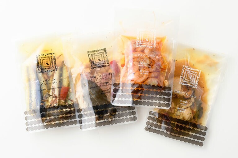 タパス各種。左から：いわしのオイルサーディン 399円(80g)、砂肝とエリンギのアヒージョ 399円(90g)、小エビのアヒージョ 462円(70g)、牡蠣のアヒージョ 399円(65g)。