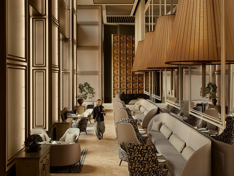 ロビ―から続く高い天井とミラーの壁に映える大きなランプシェードが、ダイナミックな空間を創り出す、5階「ジャヌ ラウンジ ＆ ガーデンテラス」。