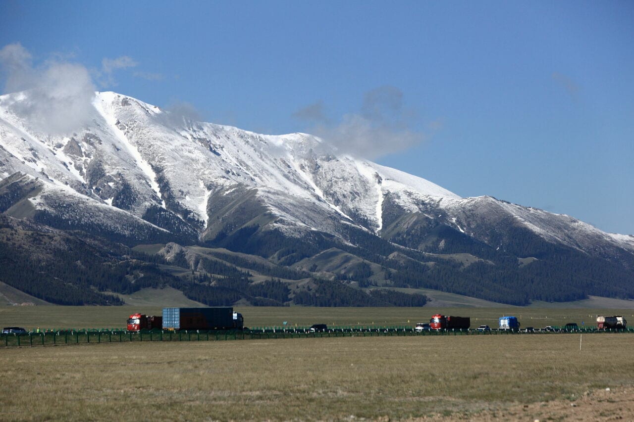 現代の天山北路を、トラックが多数往来する様子。