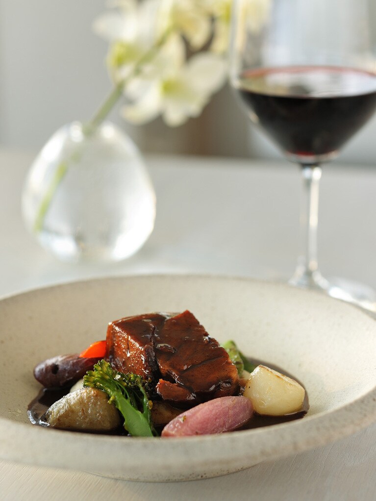 レストラン「TIN’IN（てぃんいん＝島言葉で “海と空”）」のディナーコース〈KAGISUMA -美ぎ島-〉から「宮古産山羊の赤ワイン煮込みとグリル」。やわらかく、ほろほろに煮込んだ山羊肉の深い旨みに驚くこと間違いなし！ コース1万8,975円。