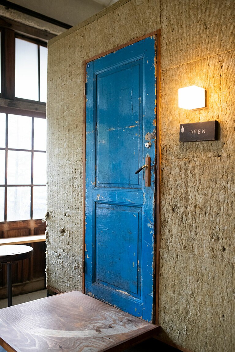 青い扉の向こうがワイン倉庫。オンラインショップで購入可。