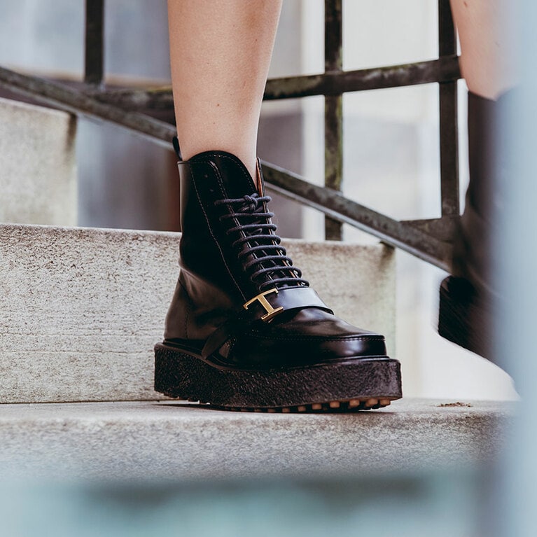 高さのある、厚めのクリーパーソールには、不動の人気を誇るシューズ「ゴンミーニ」でおなじみ、ドットのゴム突起のディテールである“ラバーペブル”を施したデザインを取り入れている。甲の部分には目を引く「T」マークが。