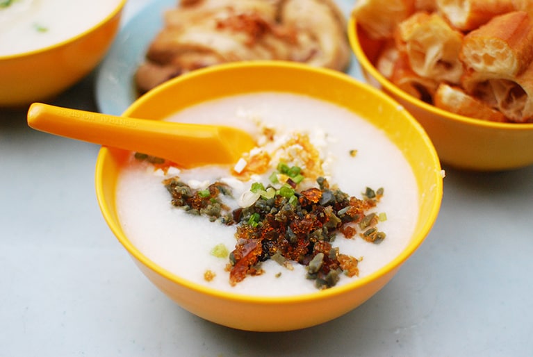 お粥はおもに華人系の店で提供されている。ピータン、豚だんご、ピーナッツ、揚げパンが定番の具。