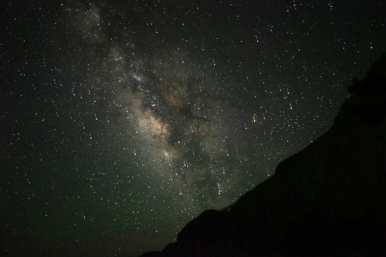鬼界カルデラの縁からのぼる天の川。イオキャラバンパーク前の芝生エリアから。