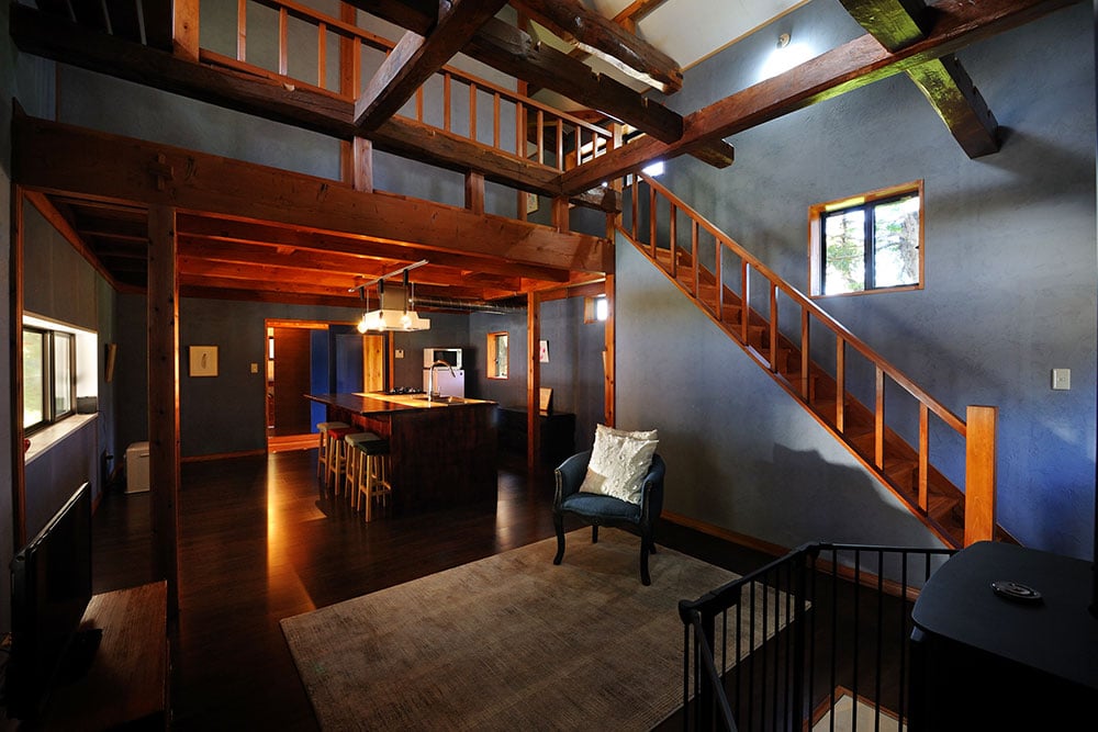 ラピスラズリの壁の色が印象的な“青の家”。吹き抜けでつながる2階は、寝室となる和室が2部屋。
