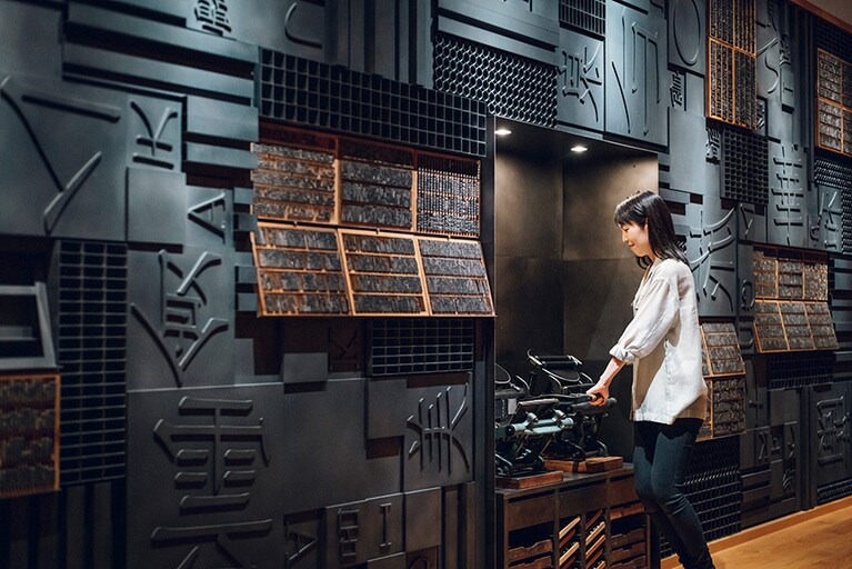 活字を並べたフレームを古い活版印刷機にセットし、ポストカードに文字をプレス。