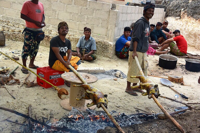 車窓から見た風景。生後3カ月の赤ちゃんをお祝いするために豚の丸焼きを用意している島民。