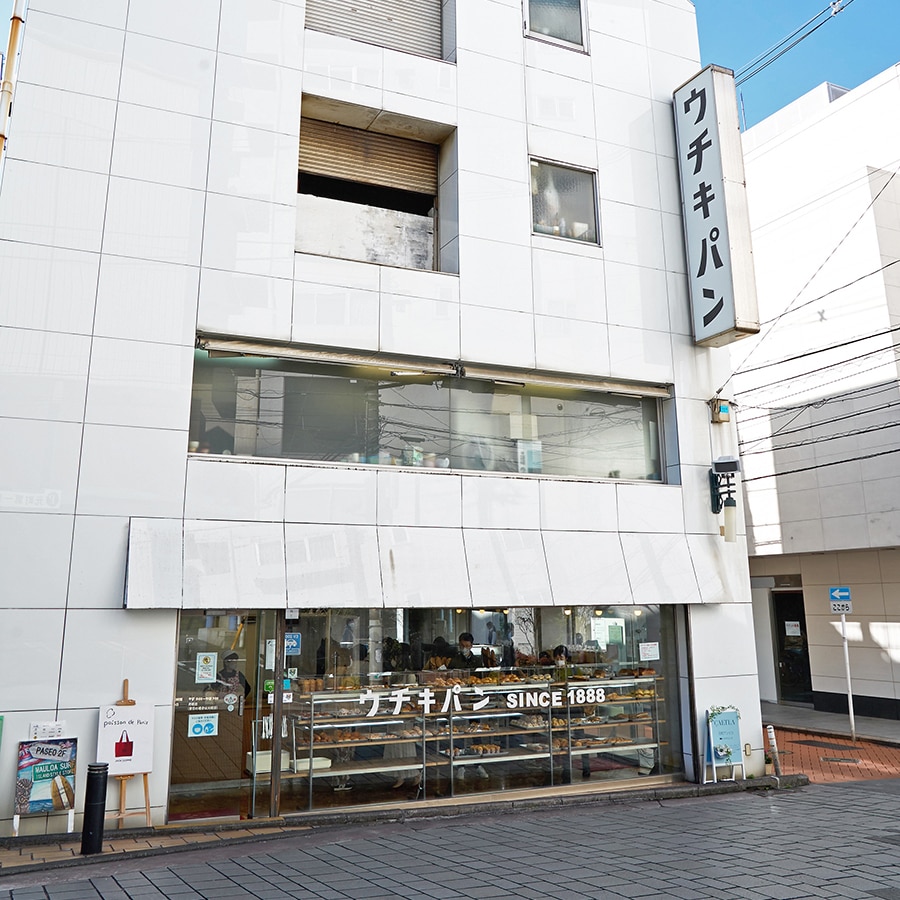 角地に建つ白い建物の1階が店舗、3階と4階でパンを焼いているそう。