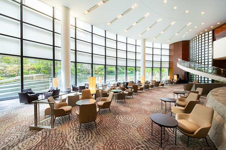 庭園の緑を借景にした、光溢れる吹き抜けのモダンな雰囲気のガーデンラウンジ「坐忘」。