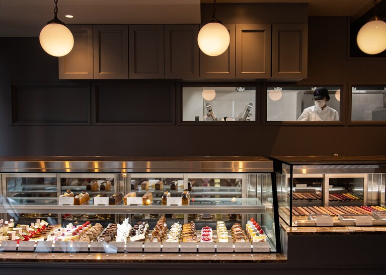 常時20種ほどのプティガトーや焼き菓子、そしてボンボンショコラがショーケースに並ぶ。ライトグレーを基調にした店内の小窓からは厨房を垣間見ることができる。店の3/4ほどが厨房となり、チョコレート工房も併設されている。