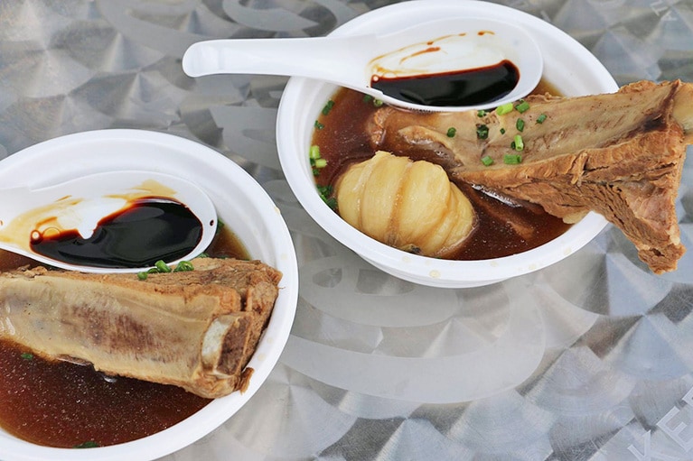 東京・十条のバクテー専門店「A1肉骨茶」が提供するバクテー(600円)。マレーシアタイプでスープが黒いのが特徴。このスープで煮込んだにんにく(100円)も絶品。ちなみにご飯と一緒に食べたい人は、2軒隣の「マレーアジアンクイジーン」で注文可。